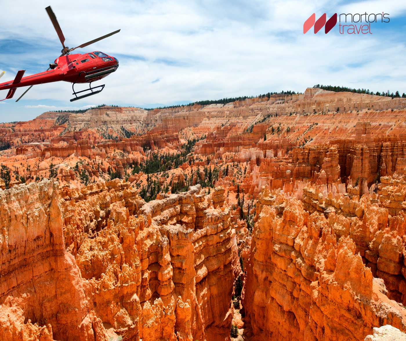 Helikopter repül a Grand Canyon vörös sziklái felett, alul a Colorado folyó látszik.